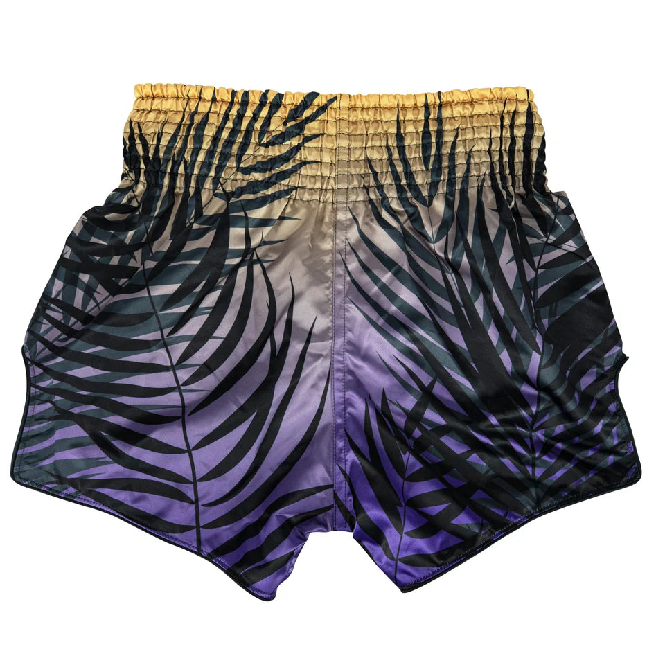 Muay Thai shorts with a palm leaf pattern transitioning from yellow to purple on a white background