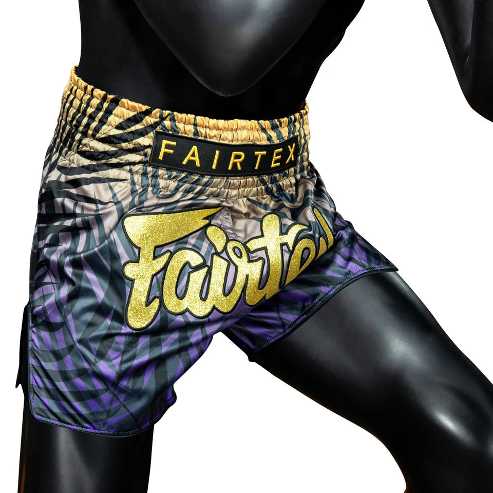 Fairtex boxing shorts with a colorful pattern on a mannequin.