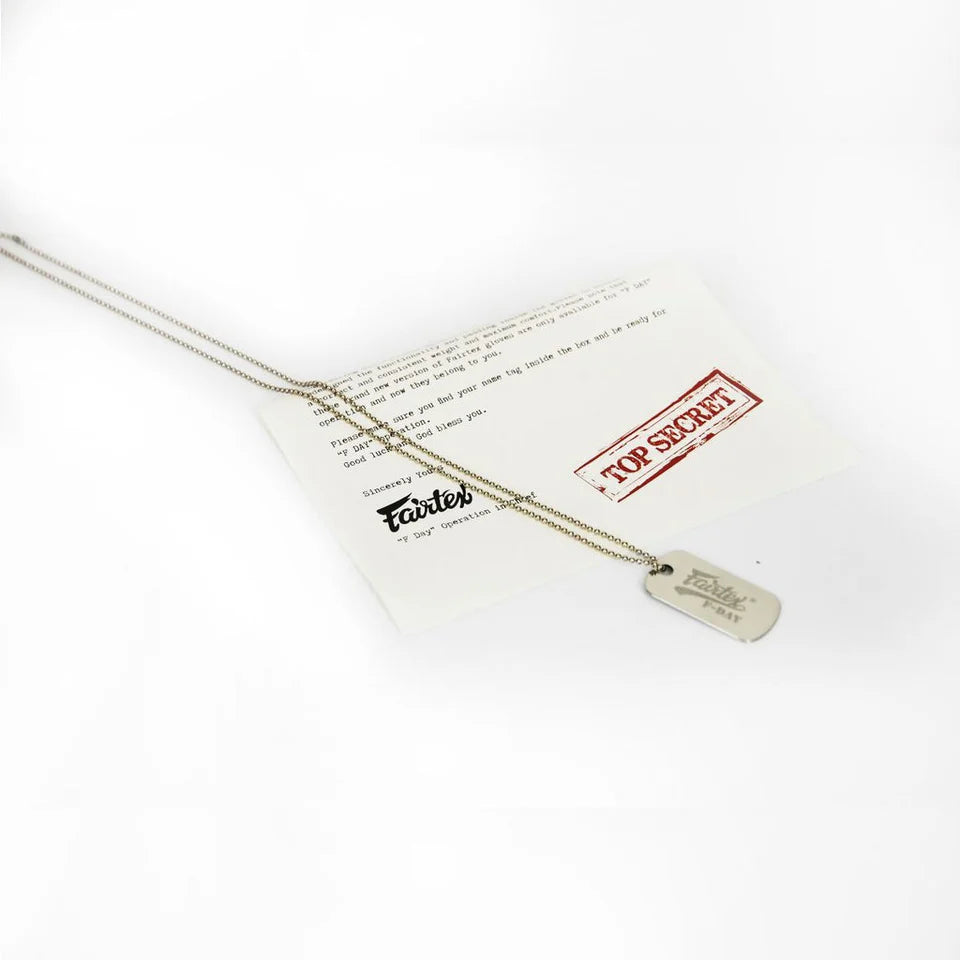 Gold necklace with a tag on a white card with text and a red stamp.