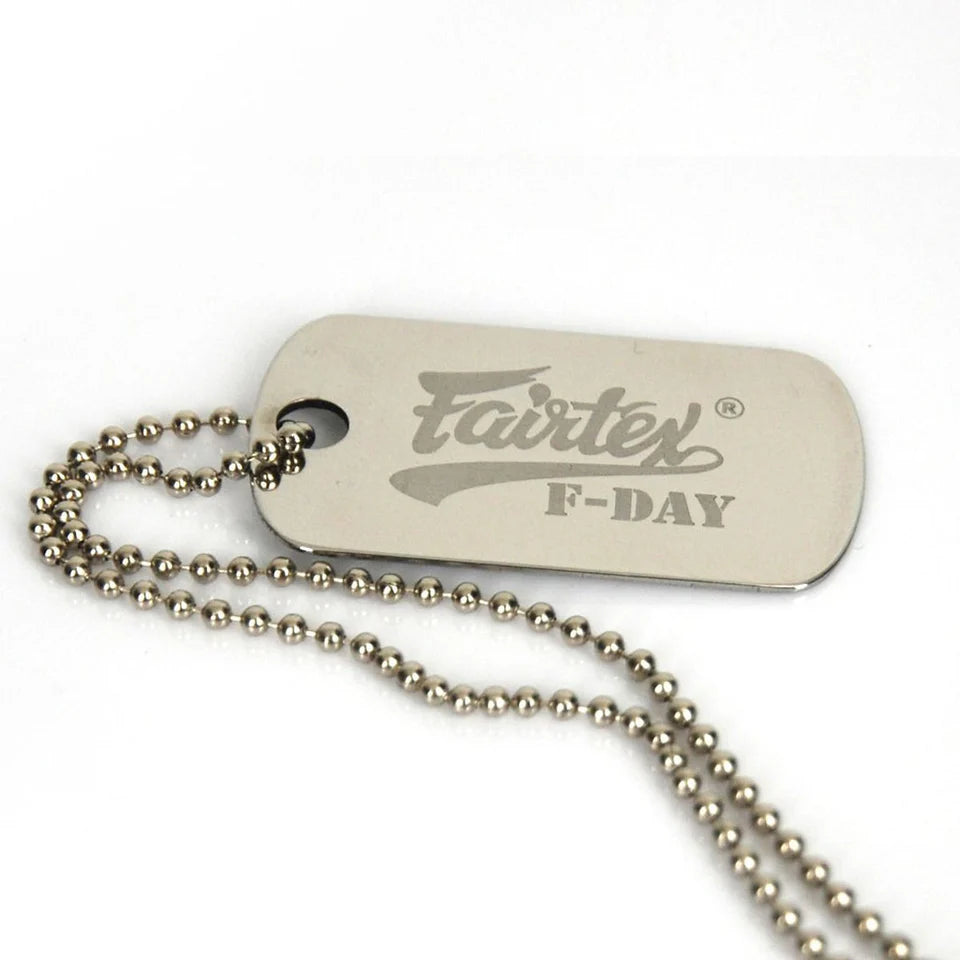 Metal dog tag with 'Fairtex' branding on a white background