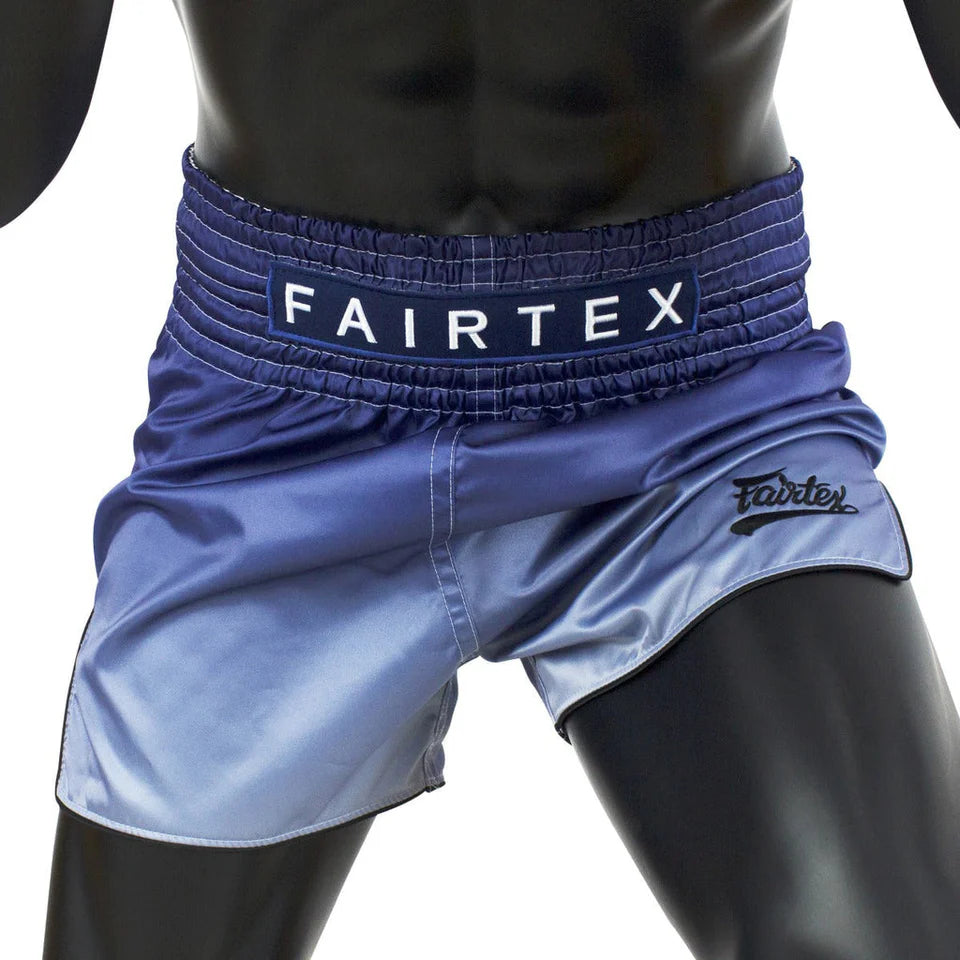 Blue Muay Thai shorts with Fairtex branding on a mannequin against a white background