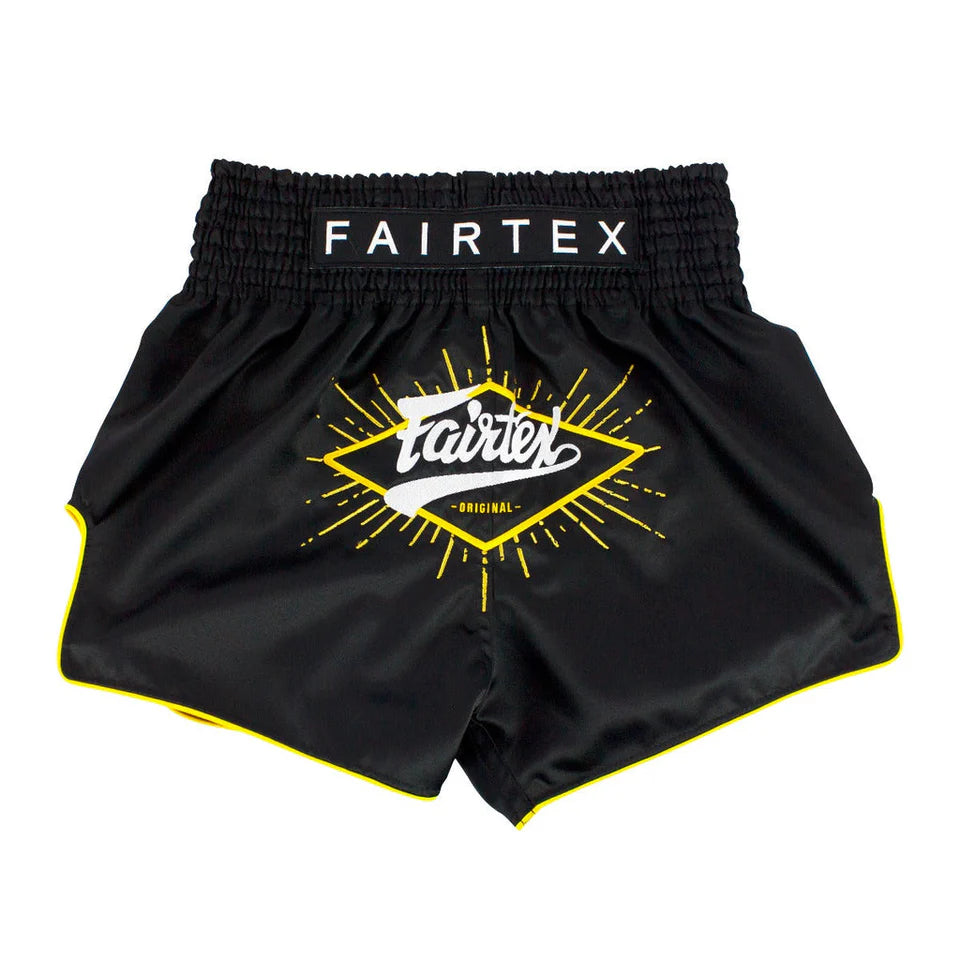 Black Fairtex shorts with yellow logo on a white background