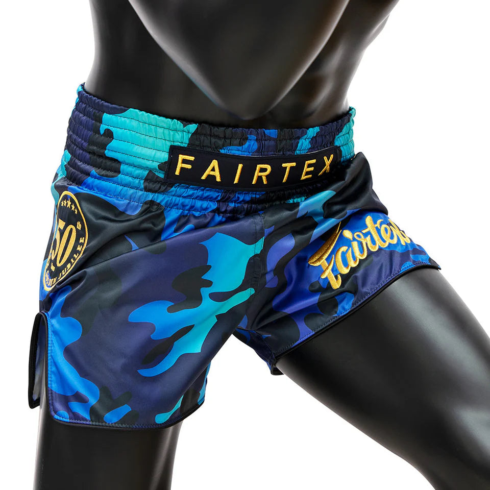 Blue camouflage Muay Thai shorts with Fairtex branding on a mannequin.