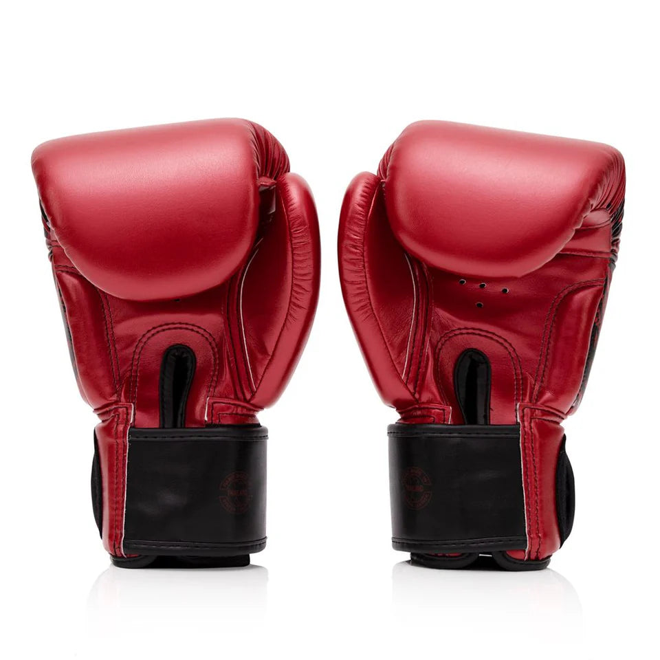 Pair of red boxing gloves with black cuffs on a white background