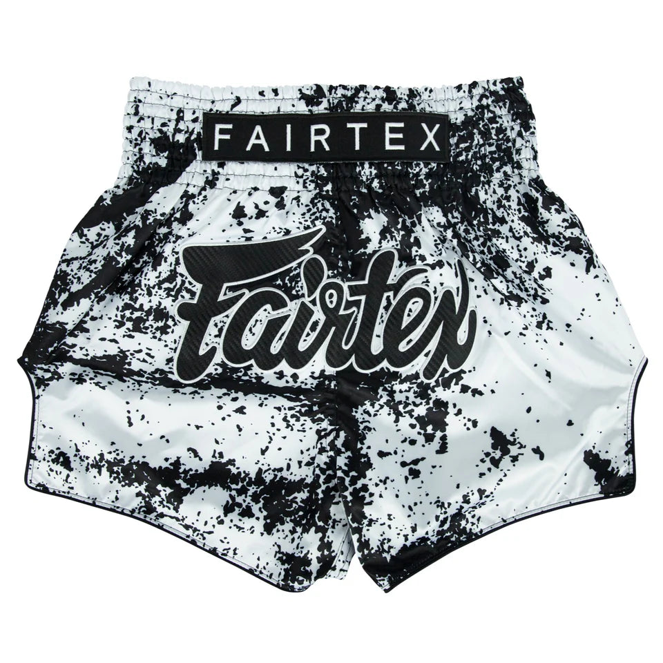 Black and white splatter-patterned boxing shorts with Fairtex branding on a white background
