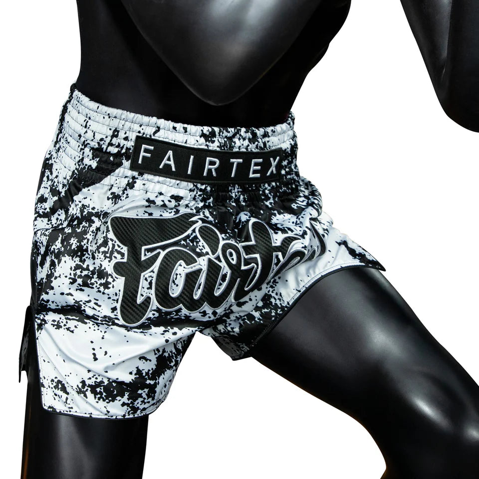 Black and white Muay Thai shorts with Fairtex branding on a mannequin.