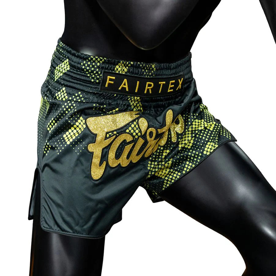 Black and green boxing shorts with 'Fairtex' branding on a mannequin.