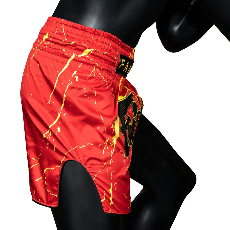 Red athletic shorts with yellow accents and a logo on a mannequin against a white background