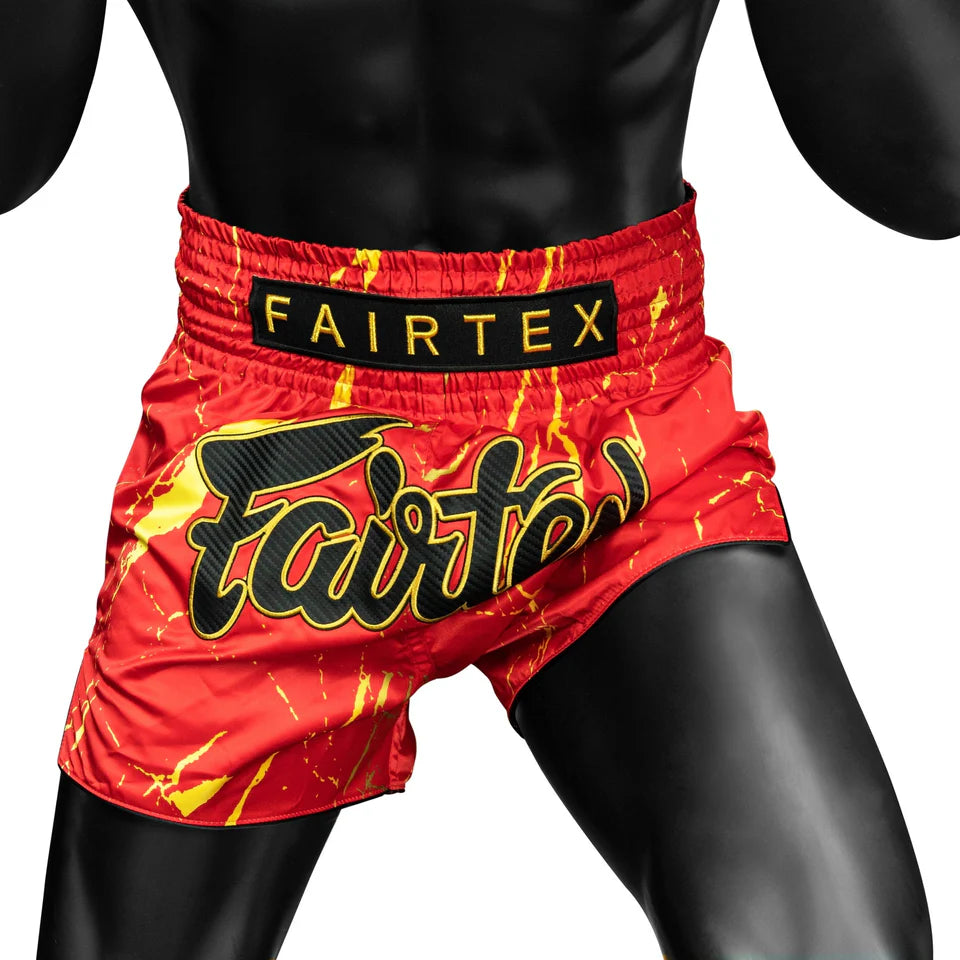 Red and yellow boxing shorts with Fairtex branding on a white background