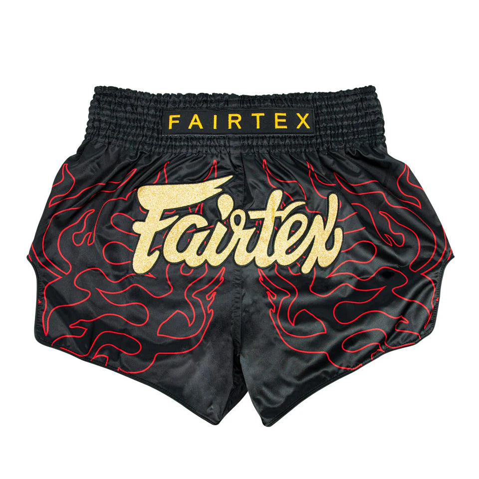 Black Muay Thai shorts with red patterns and Fairtex branding on a white background