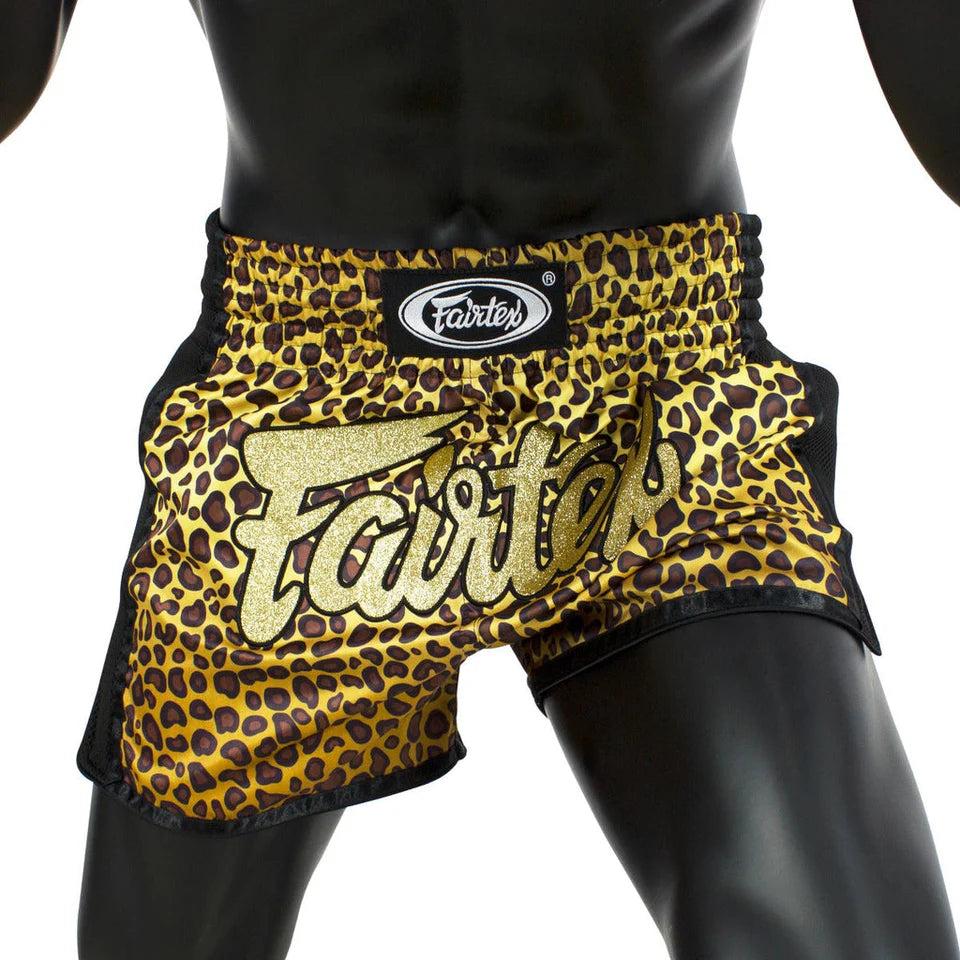 Leopard print Muay Thai shorts with 'Fairtex' branding on a black background