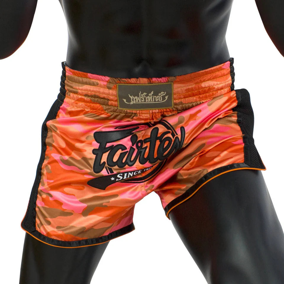 Orange and pink Muay Thai shorts with 'Fairtex' branding on a white background