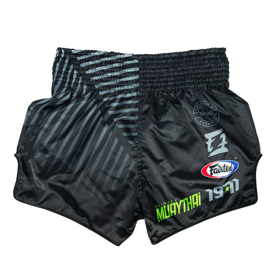 Black Muay Thai shorts with brand logos on a white background
