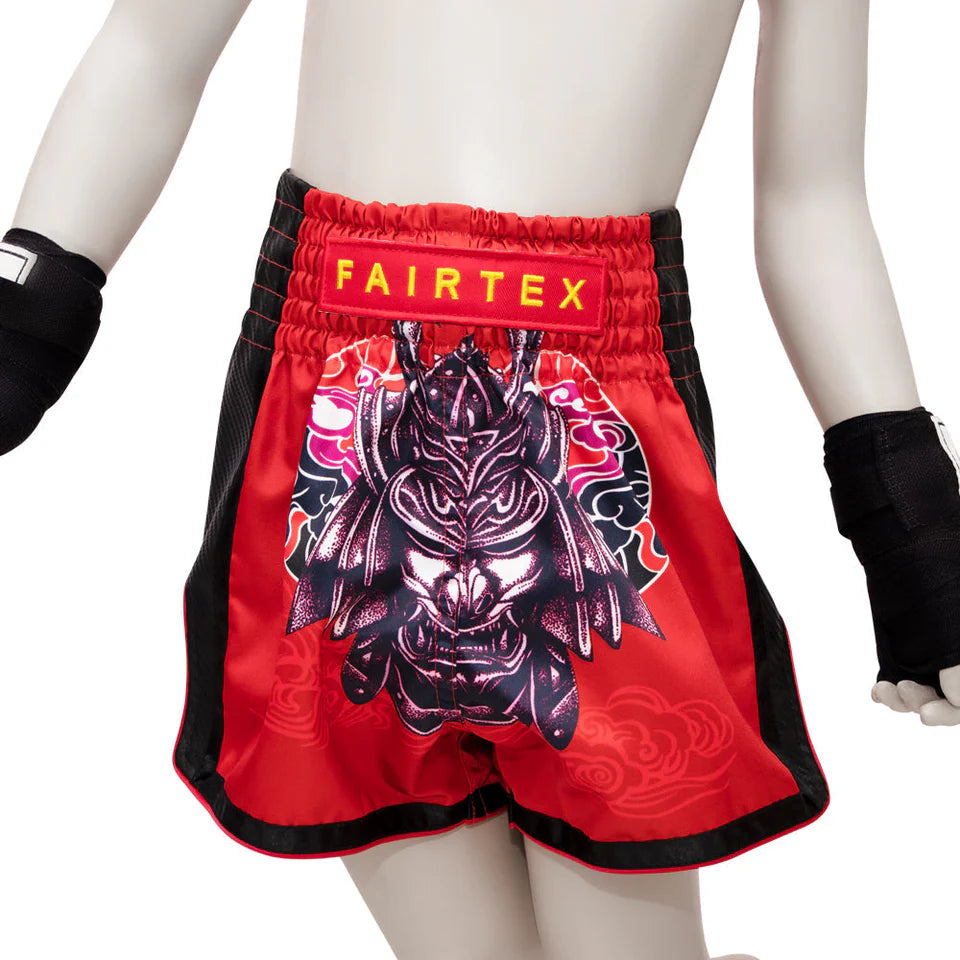Red Fairtex boxing shorts with a black and white graphic design on a white background