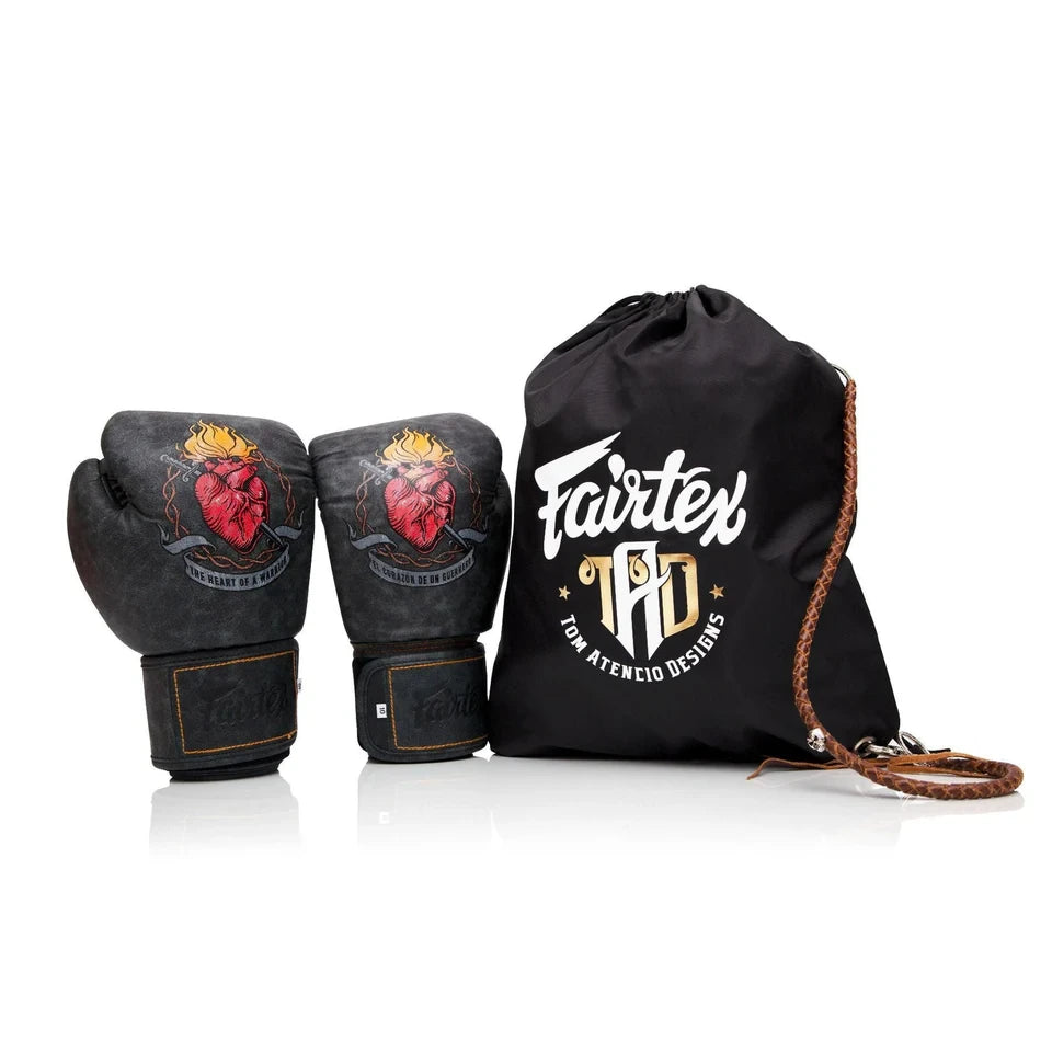 Pair of black boxing gloves with red heart design and a black drawstring bag with 'Fairtex' branding on a white background.