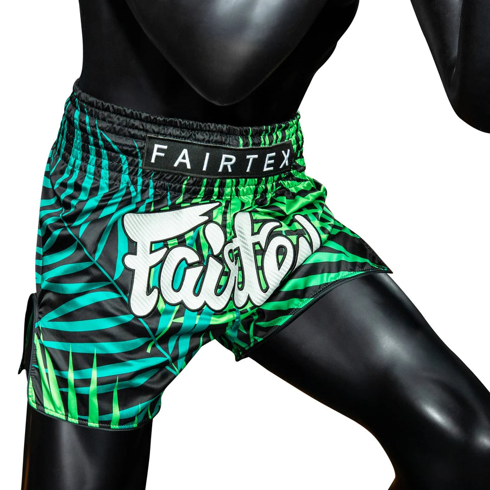 Green and black patterned Fairtex shorts on a mannequin against a white background