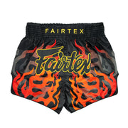 Black Muay Thai shorts with red flames and Fairtex branding on a white background