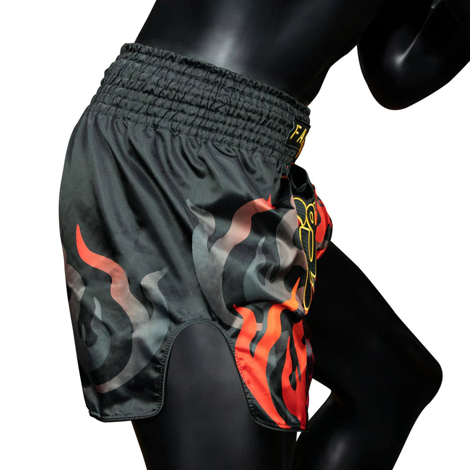 Black Muay Thai shorts with flame design on a mannequin against a white background