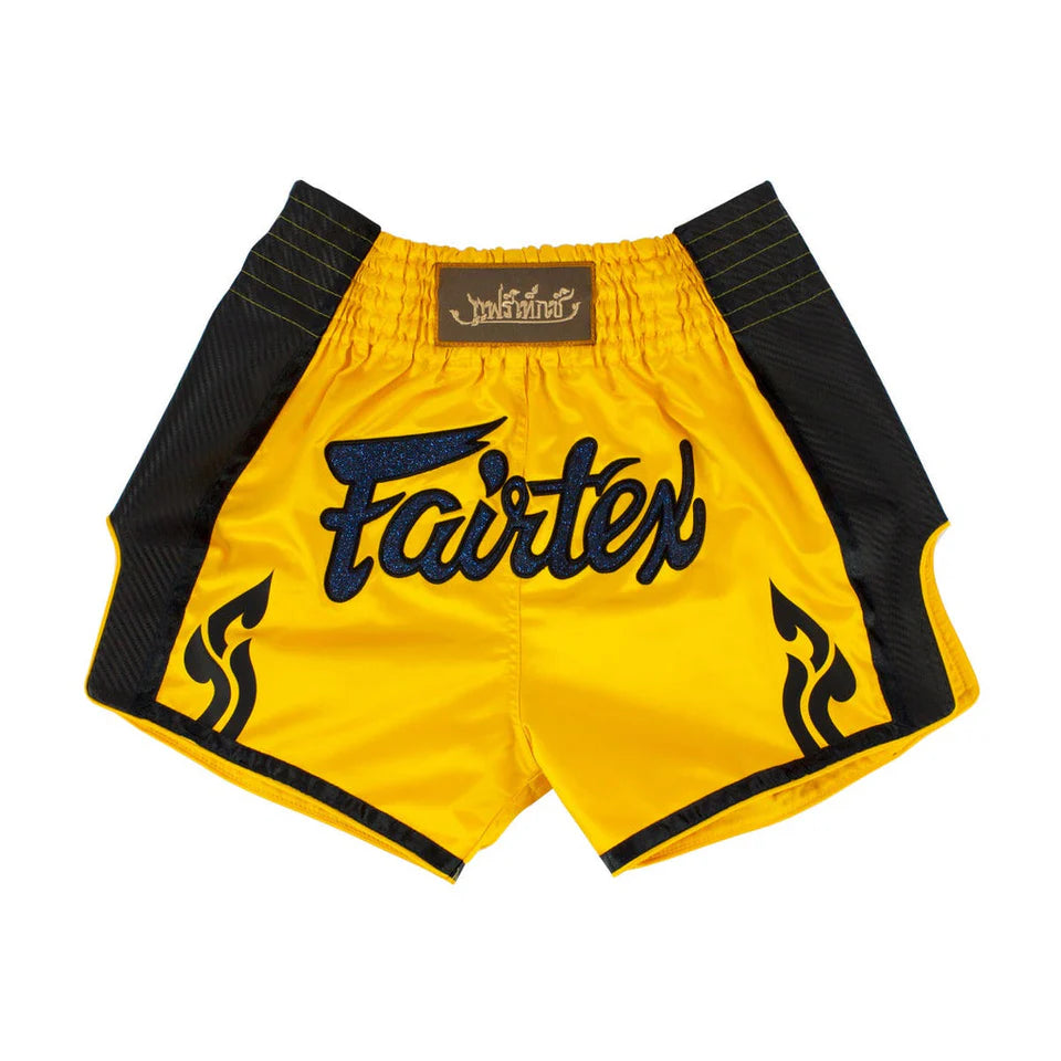 Yellow Muay Thai shorts with black accents and Fairtex branding on a white background