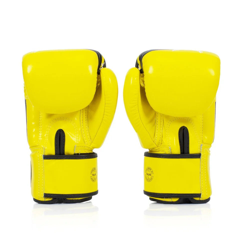 Pair of yellow boxing gloves with black accents on a white background