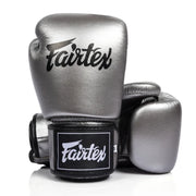 Pair of metallic boxing gloves with Fairtex logo on a white background