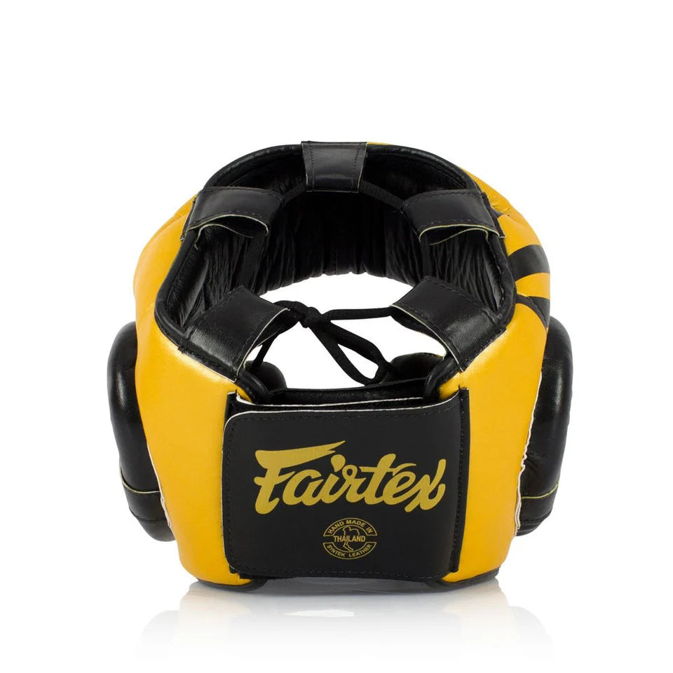 Rear profile of a yellow and black boxing headgear with Fairtex logo on a white background