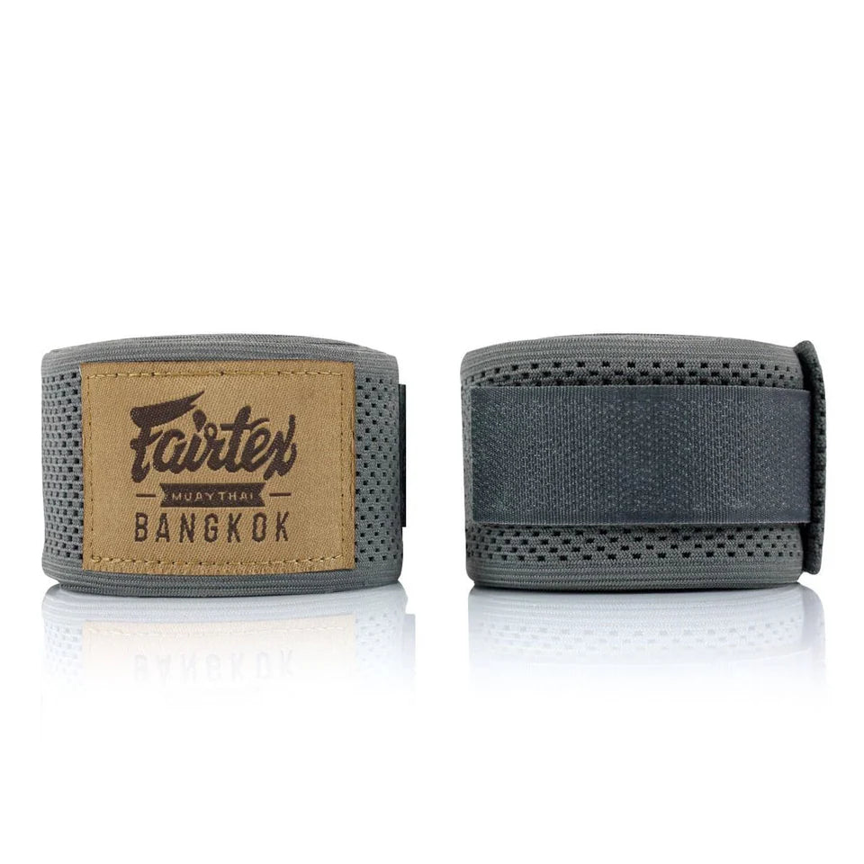 Pair of gray boxing hand wraps with Fairtex logo on a white background