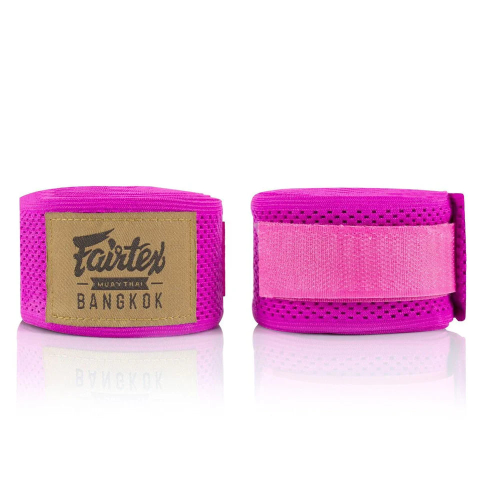 Pink boxing hand wraps with Fairtex branding on a white background