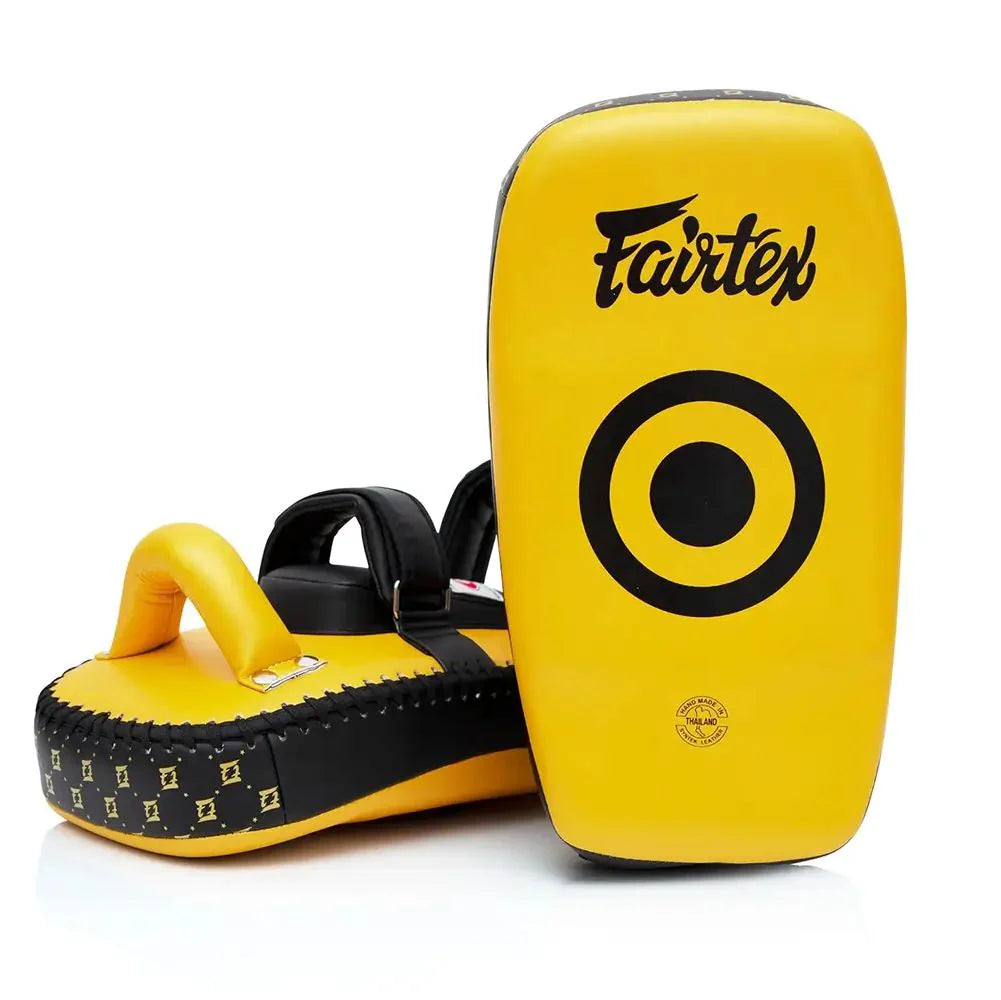 Yellow and black Fairtex Muay Thai pads on a white background