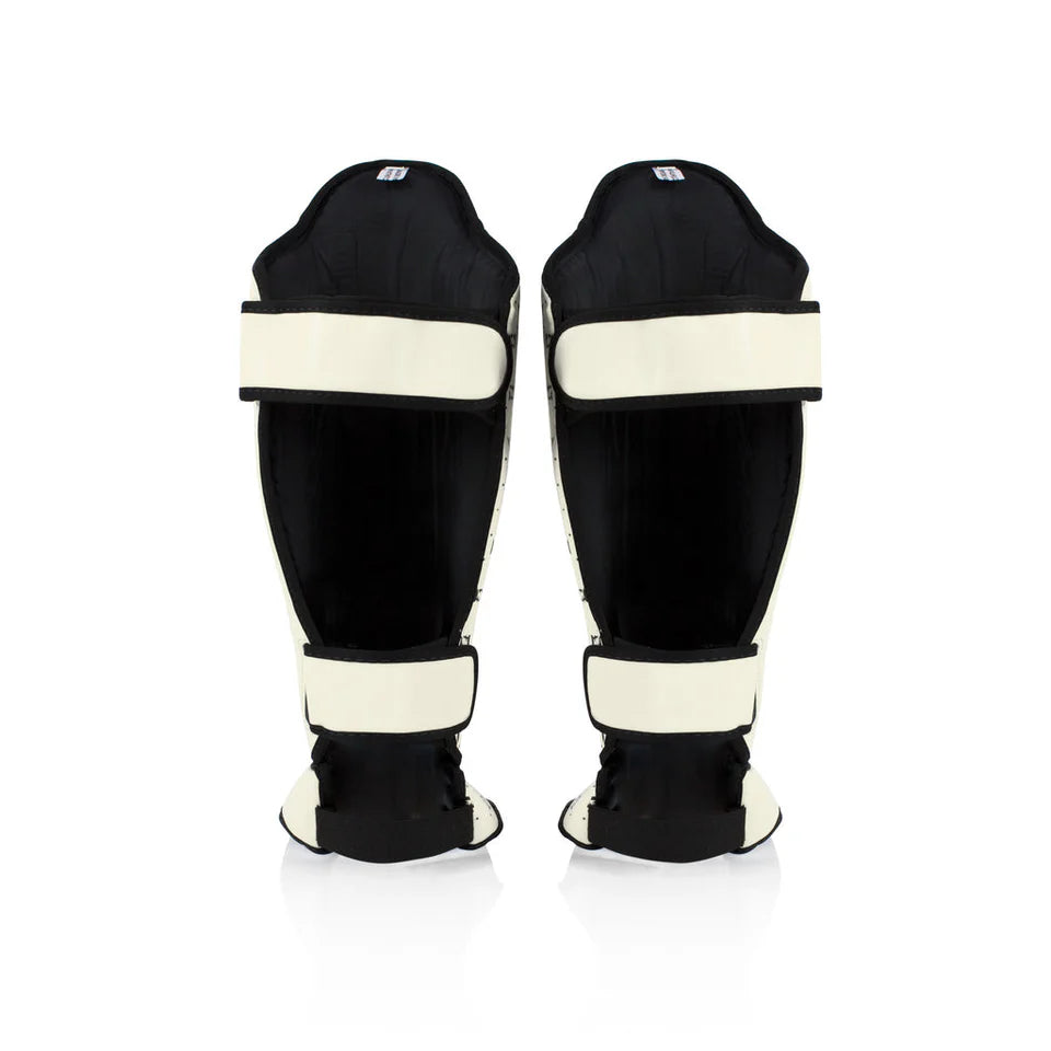 Pair of black shin guards with white accents on a white background