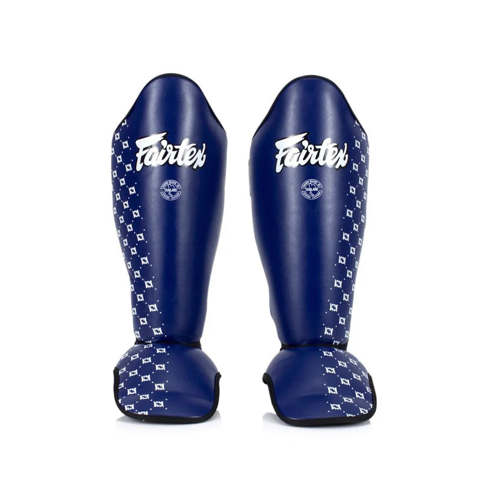 Pair of blue Fairtex shin guards on a white background