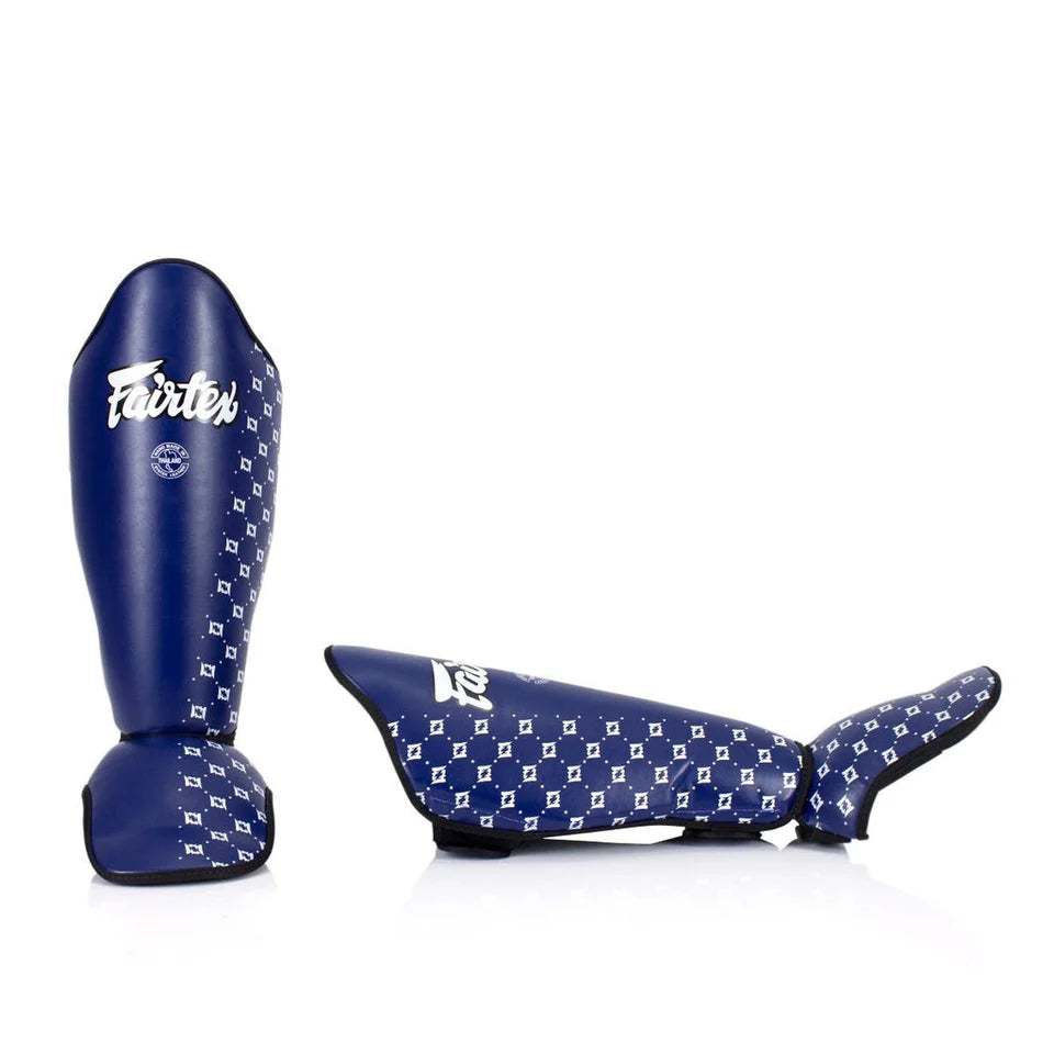 Pair of blue Fairtex shin guards with white pattern on a white background