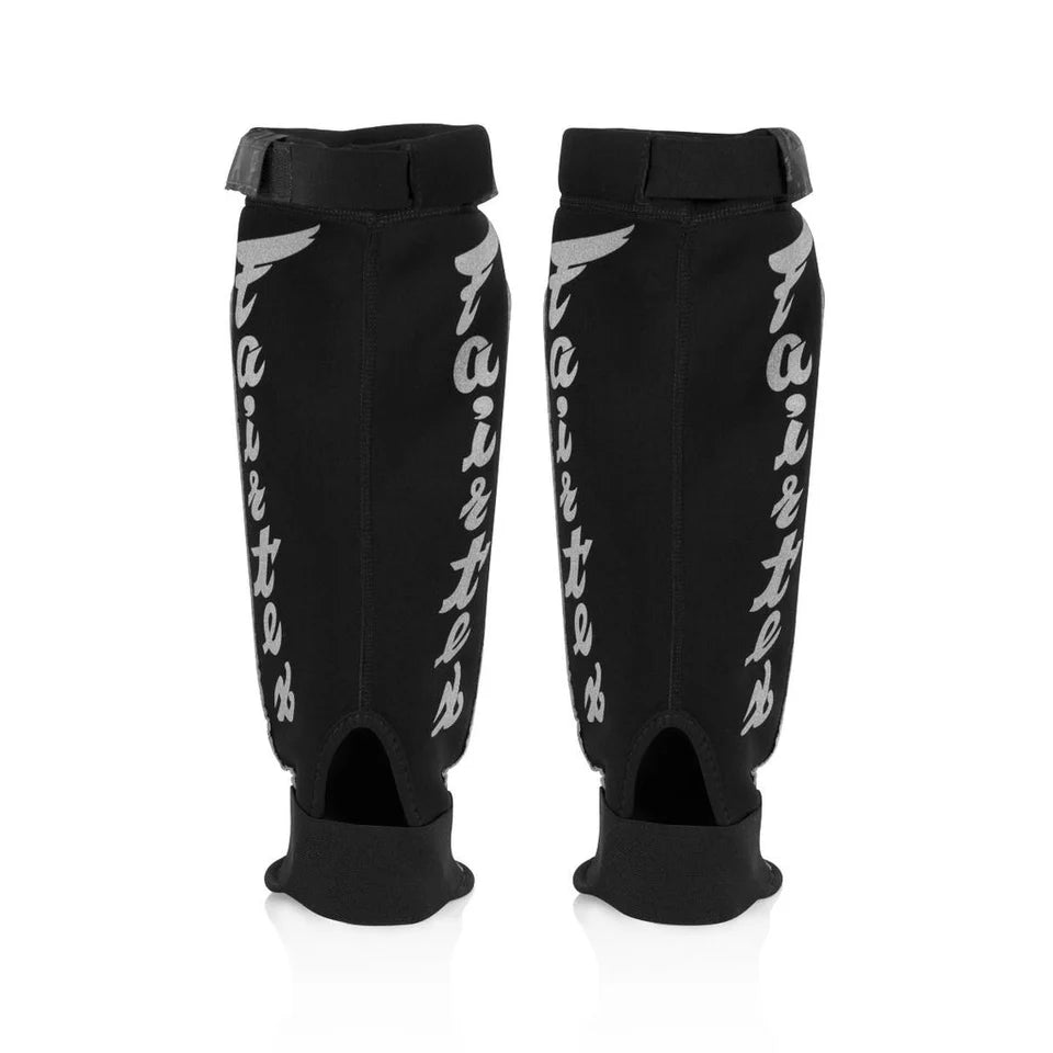 Pair of black shin guards with white branding on a white background