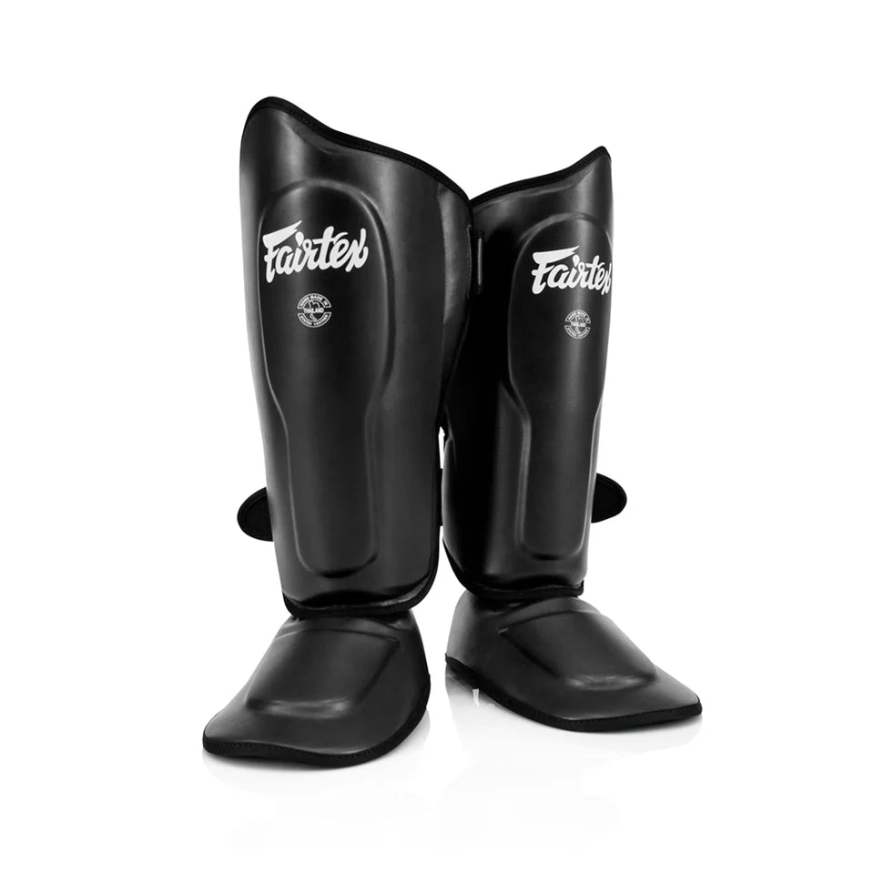 Pair of black Fairtex shin guards on a white background