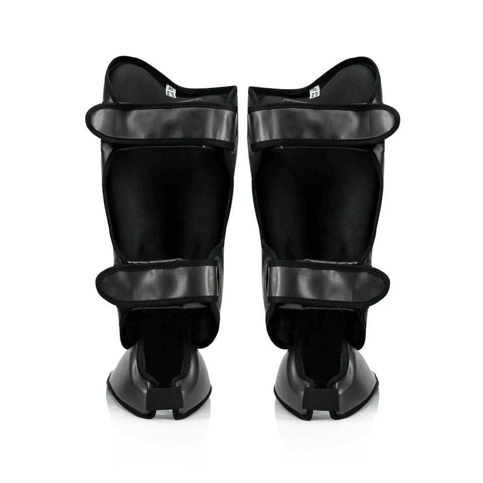 Pair of black shin guards on a white background