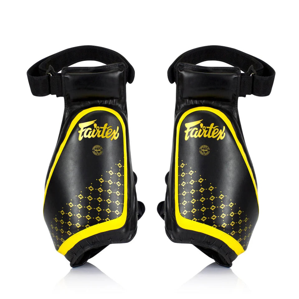 Pair of black and yellow Fairtex thigh pads on a white background