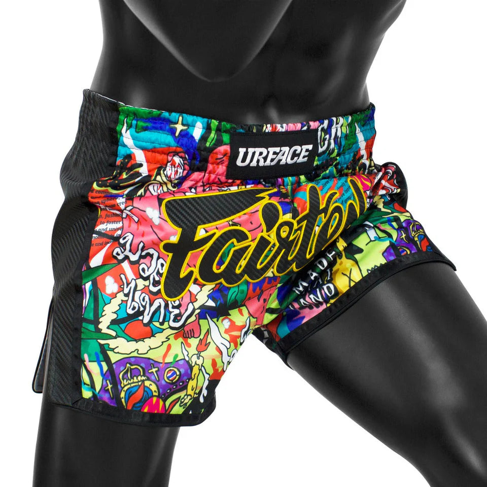 Colorful Muay Thai shorts with a brand logo on a black background
