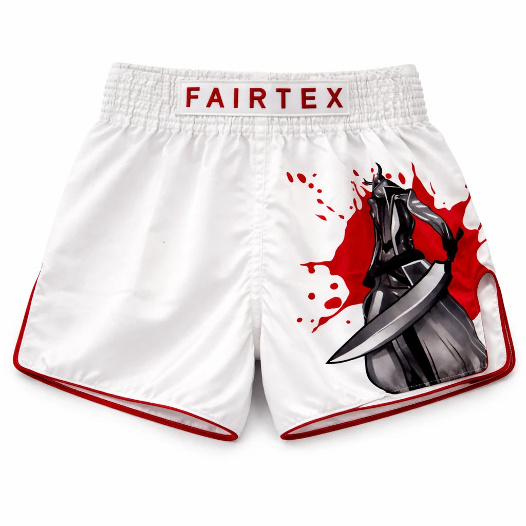 White boxing shorts with red accents and Fairtex branding, featuring a graphic design on the side.