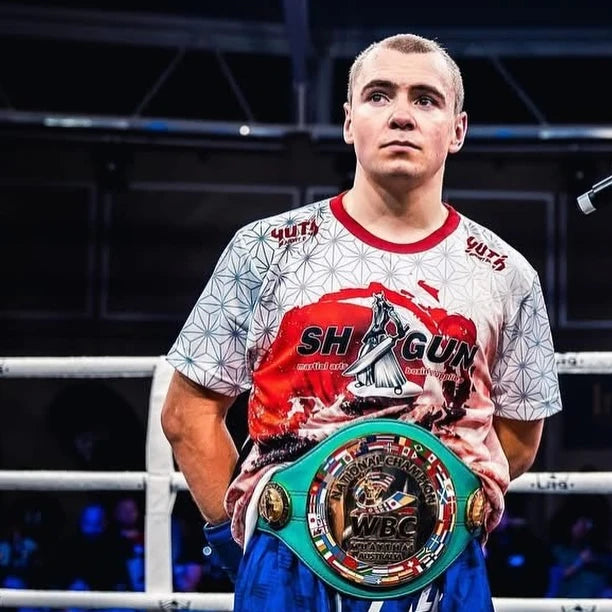 Person holding a WBC championship belt in a boxing ring