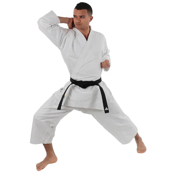 Male wearing a white martial arts uniform with a black belt on a white background