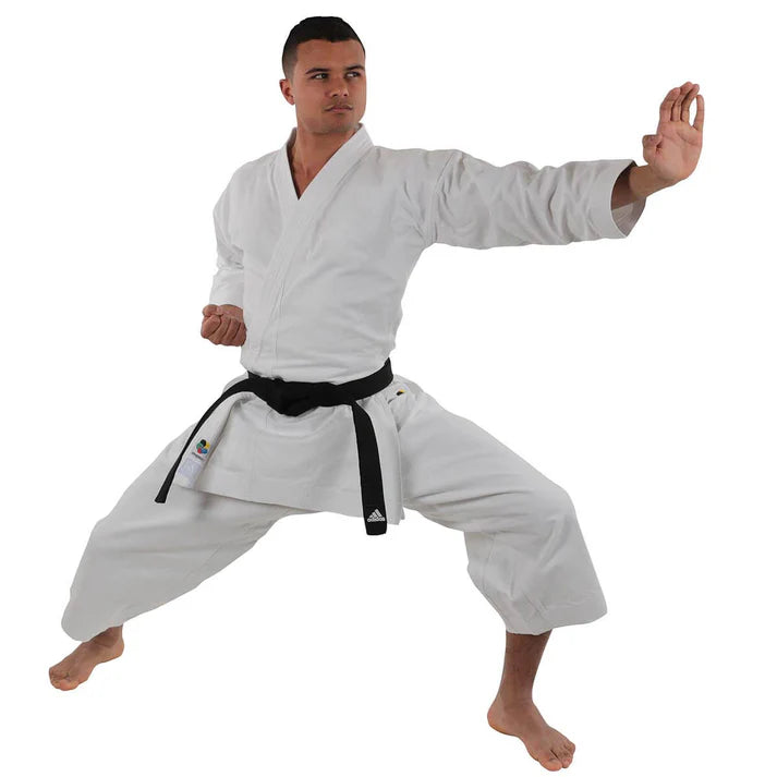 Male wearing a white martial arts uniform with a black belt on a white background