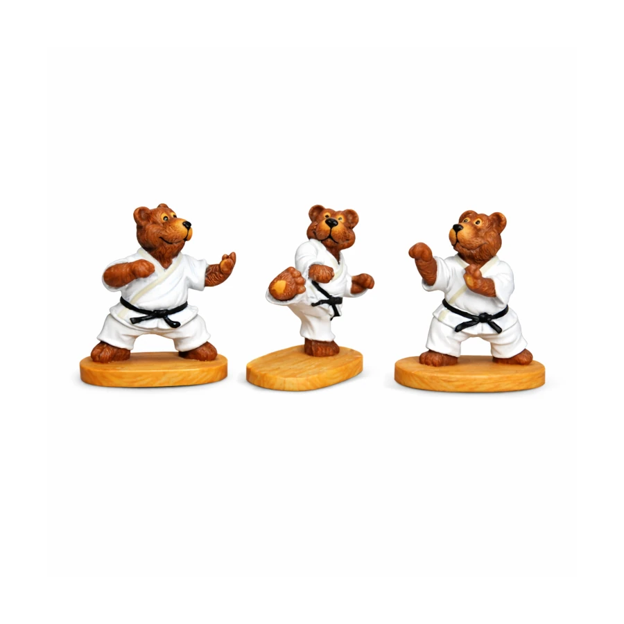 Three bear figurines in martial arts poses on a white background