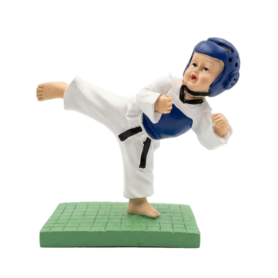 Figurine of a martial artist in a white gi with a blue headgear on a green mat.