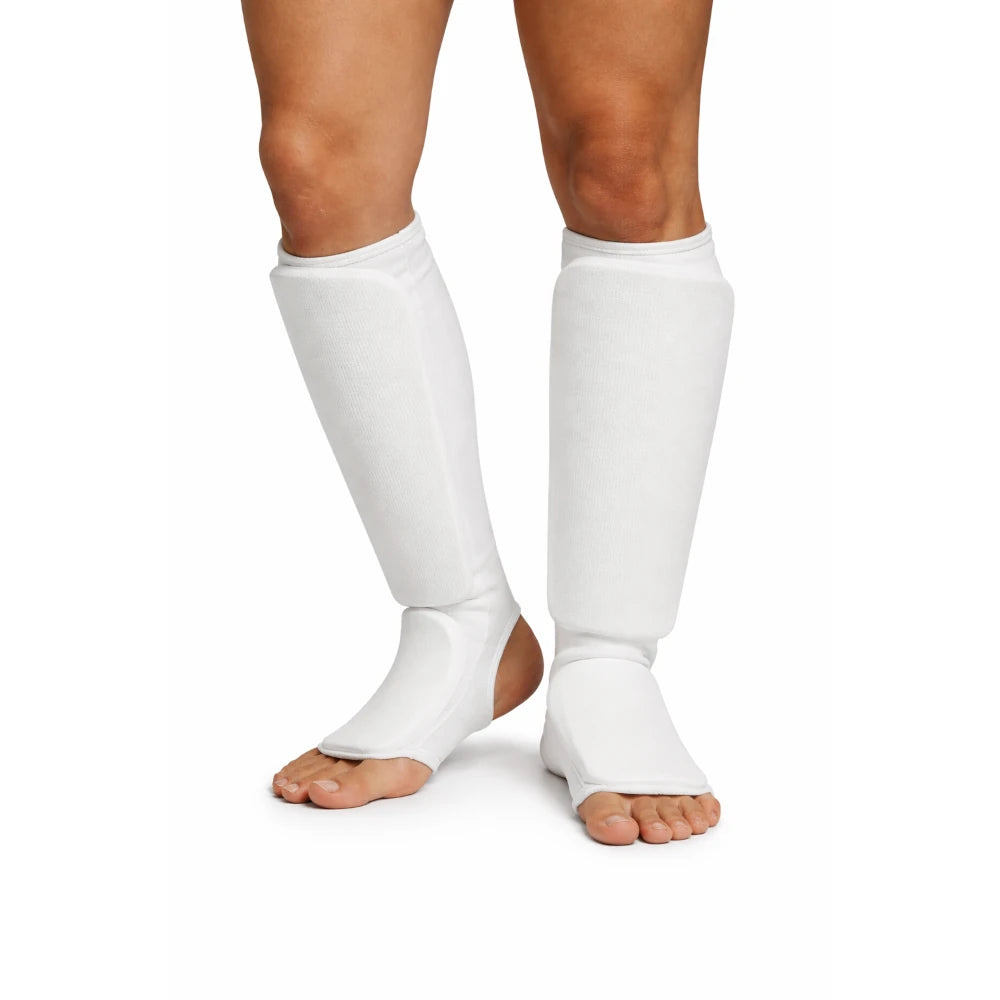 White shin pads worn by a person on a white background