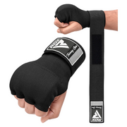 Person wearing black boxing quick wraps with RDX branding on a white background