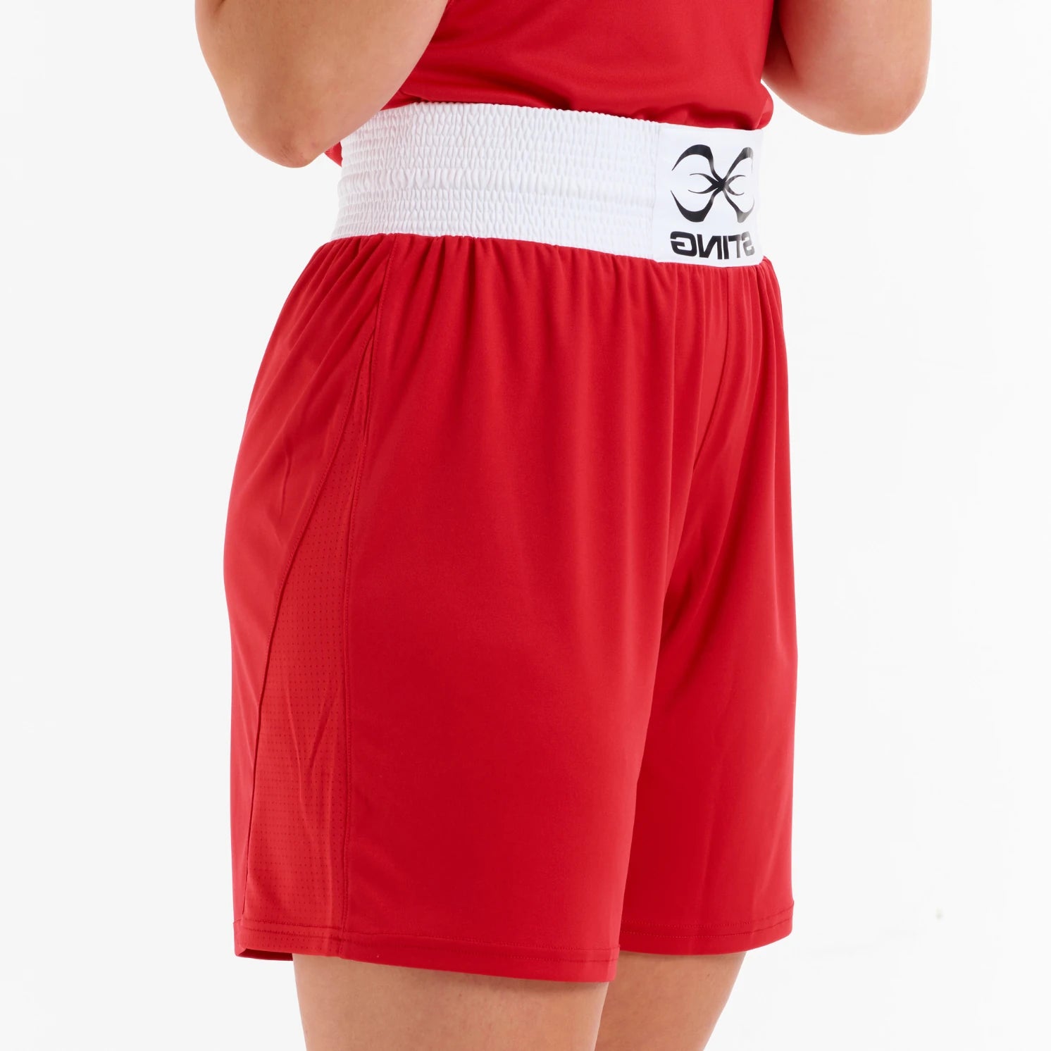 Red boxing shorts with a white waistband featuring a logo on a white background
