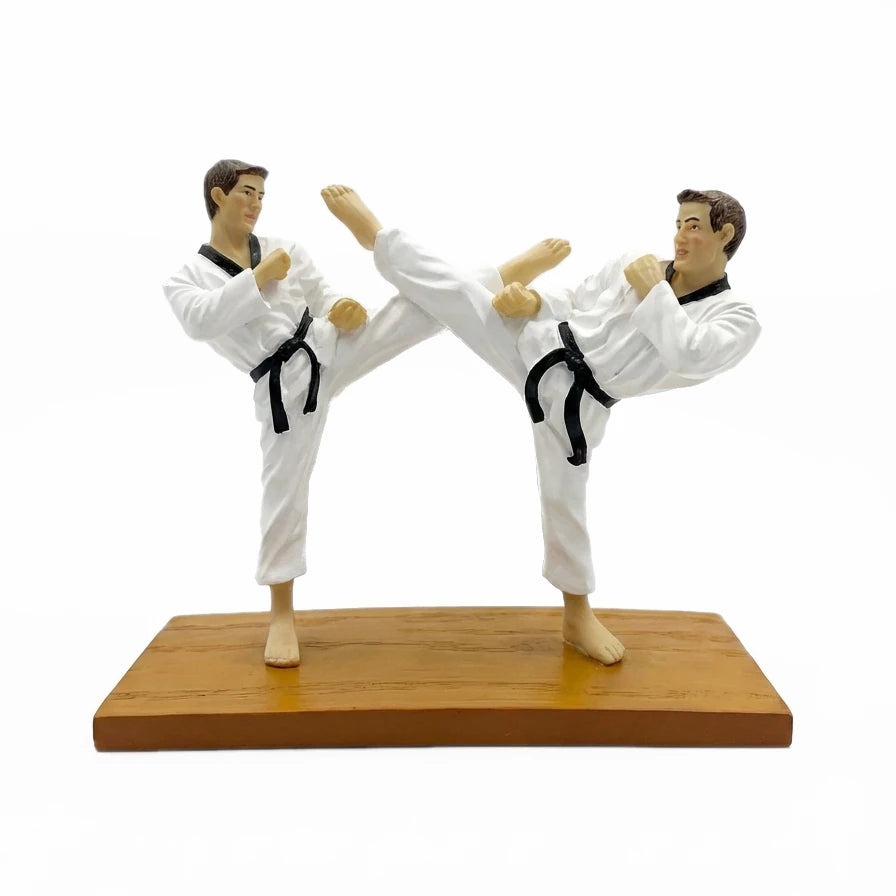 Two karate figures in a dynamic pose on a wooden platform with a white background