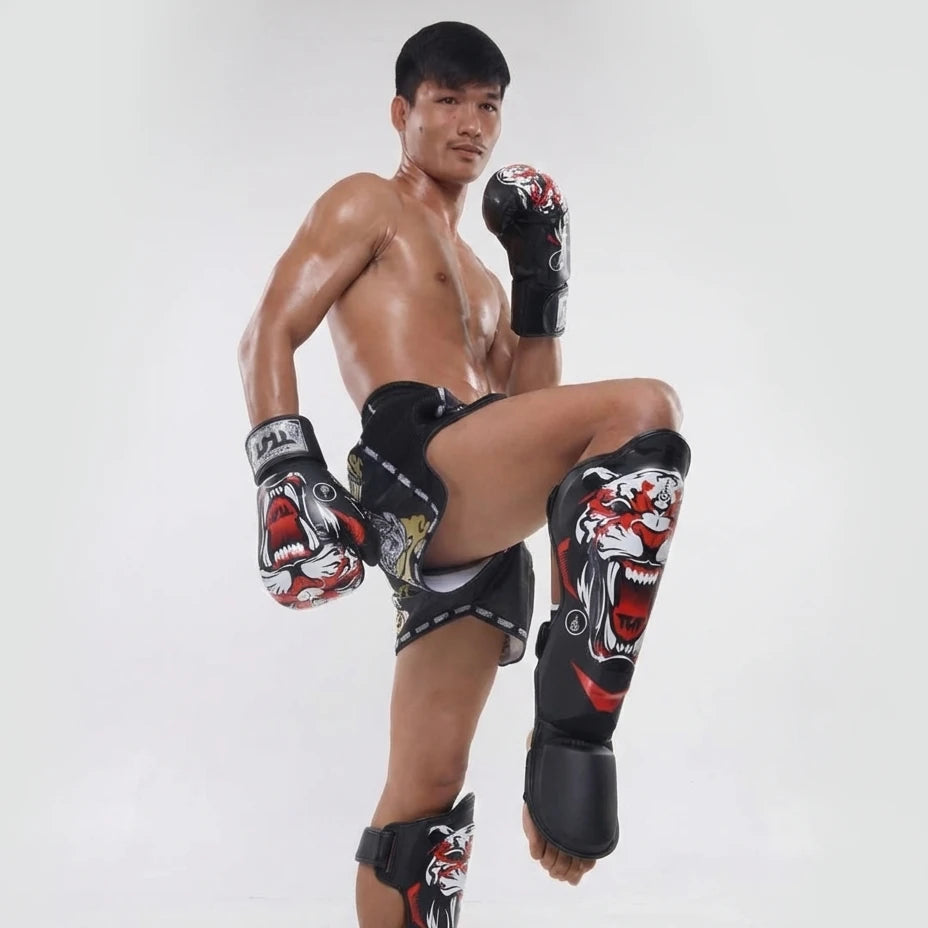 Man wearing boxing gloves and shin guards on a white background