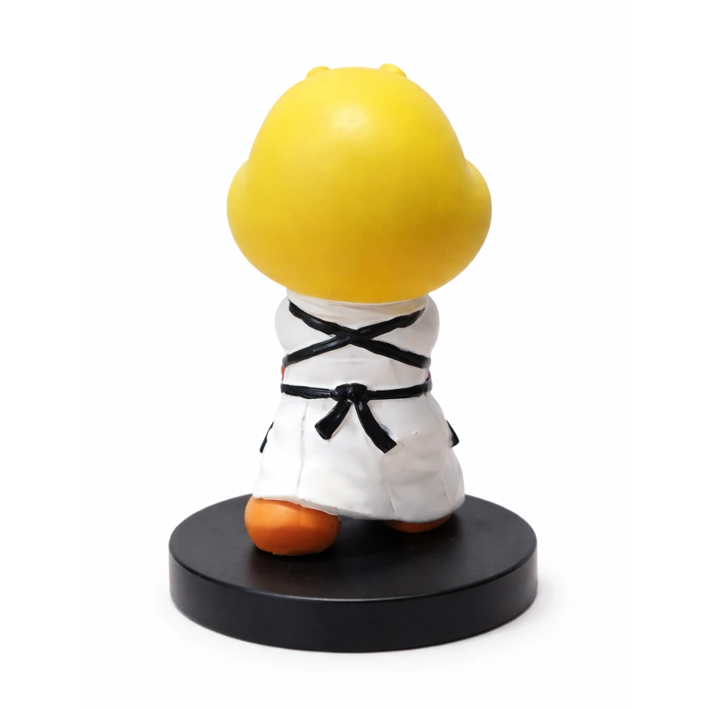 Figurine of a character in a white martial arts uniform with a yellow head on a black base against a white background