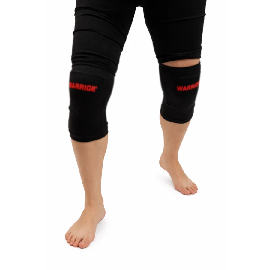 Black knee sleeves with red 'Warrior' logo worn by a person on a white background